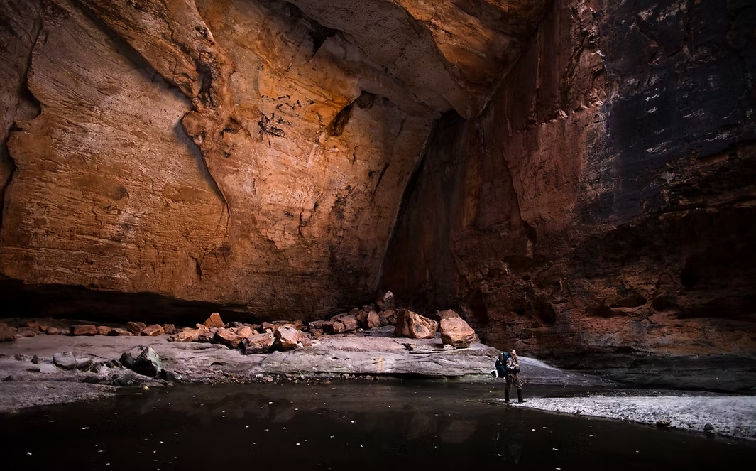 Sarah Marquis on a high alpine ridge, looking out over a vast mountain landscape